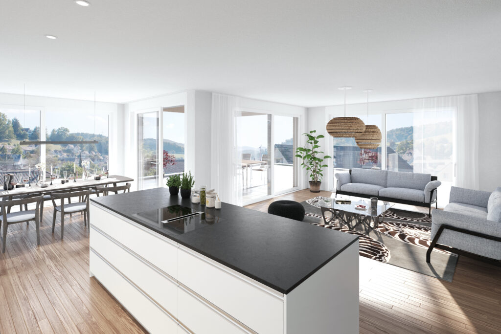 Moderne, offen gestaltete Küche mit Wohnbereich, großen Fenstern, einer zentralen Kücheninsel, einem Esstisch, grauen Sofas, Zimmerpflanzen und Blick auf Bäume und Hügel im Freien.